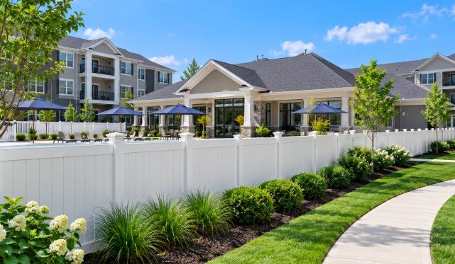 White vinyl privacy fence around an apartment community pool and clubhouse